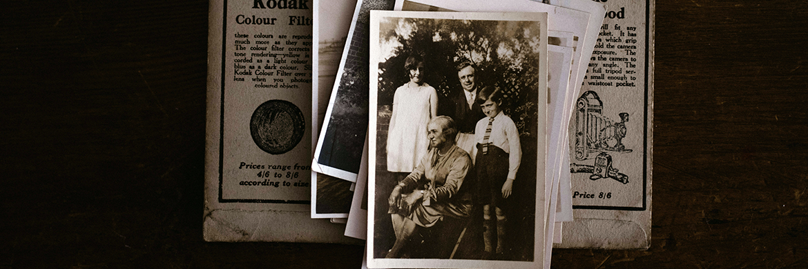 Stack of old documents and black and white historical photos of people