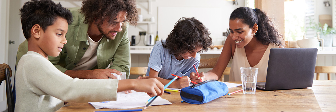Two adults teaching children at a table.