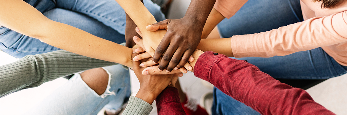 Several people putting their hands together.