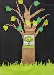 Paper tree with green leaves that have poems written on them