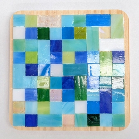 Glass tile mosaic coaster in shades of green and blue.