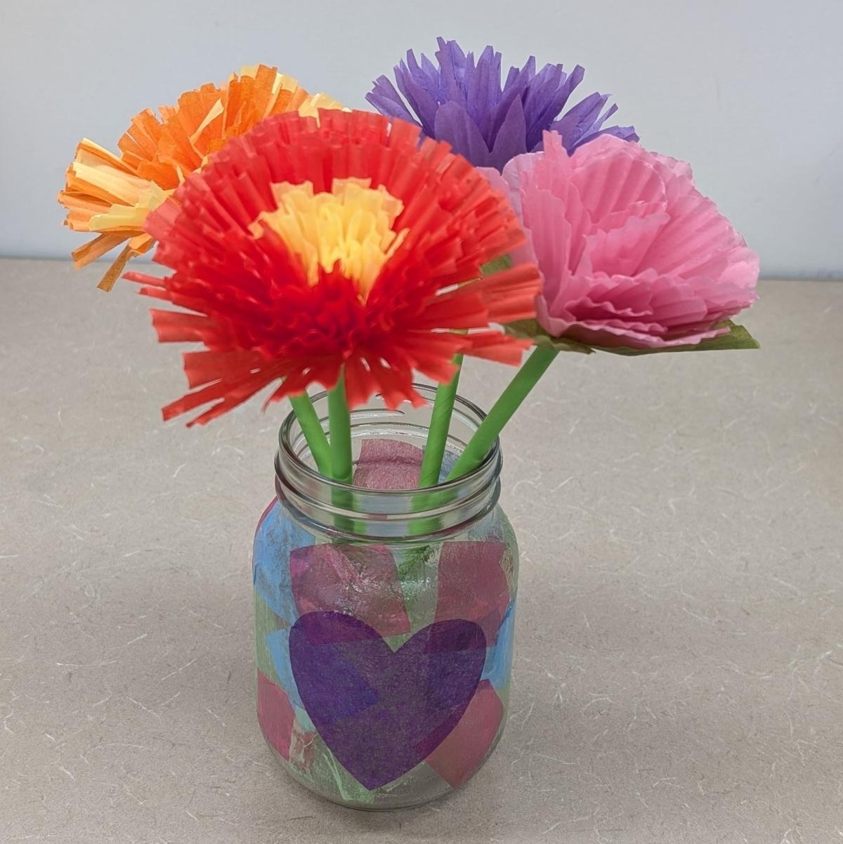 Flowers made of cupcake liners in a decorated mason jar.