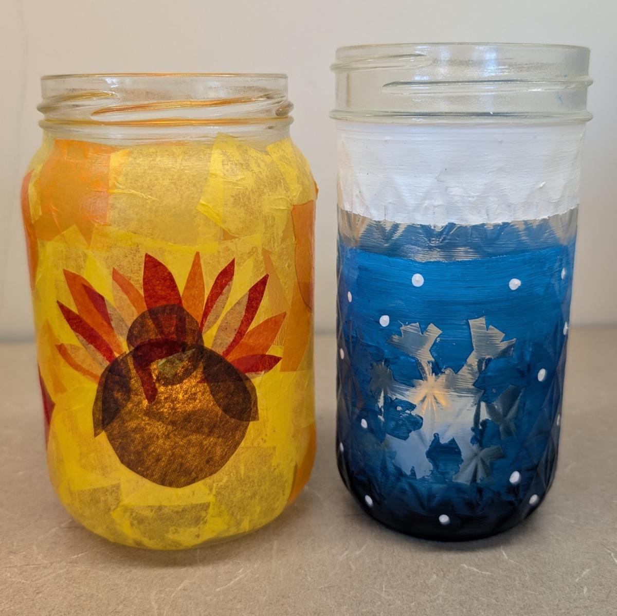 2 Mason jar lanterns one with a Thanksgiving theme and one with a winter theme.