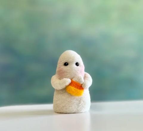 needle felted ghost figure holding candy corn
