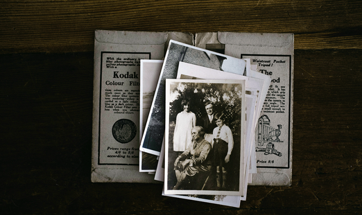 Stack of old documents and black and white photos of people