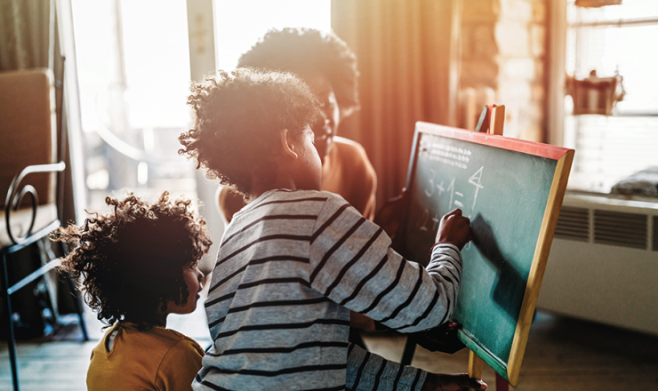 Mom and sons doing math equations on a chalkboard